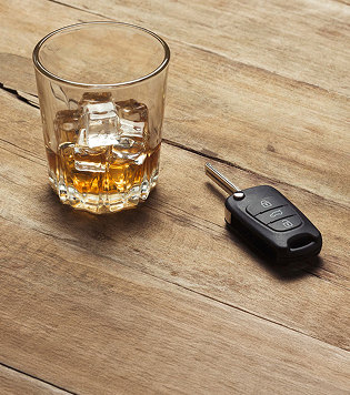Glass with whiskey and ice and car keys on a wooden background 1